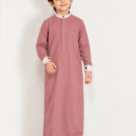 Give your little one a smart and elegant traditional look with the **Isliba Dusty Rose Thobe for Boys**. Featuring a sophisticated dusty rose color, a contrasting cream collar and cuffs, and a clean, minimal design, this thobe is perfect for everyday Islamic wear and special occasions. **Product Features:** - **Elegant Dusty Rose Color:** A modern and stylish shade for boys. - **Minimal Design:** Clean front placket with no embroidery for a simple, refined appearance. - **Contrast Detailing:** Cream stand collar and sleeve cuffs with dark buttons. - **Practical Chest Pocket:** Adds functionality while maintaining a neat look. - **Full Sleeves:** Designed for a classic traditional appearance. - **Versatile Occasion Wear:** Suitable for Eid, Ramadan, Jummah prayers, family gatherings, and festive occasions. **Product Details:** - Brand: Isliba - Product Type: Boys' Thobe / Arabic Jubba - Color: Dusty Rose - Collar: Cream Stand Collar - Sleeves: Full Sleeve - Design: Plain / Minimal - Available Sizes: As per size selection Choose Isliba for a timeless Islamic outfit that combines simplicity, style, and traditional elegance.