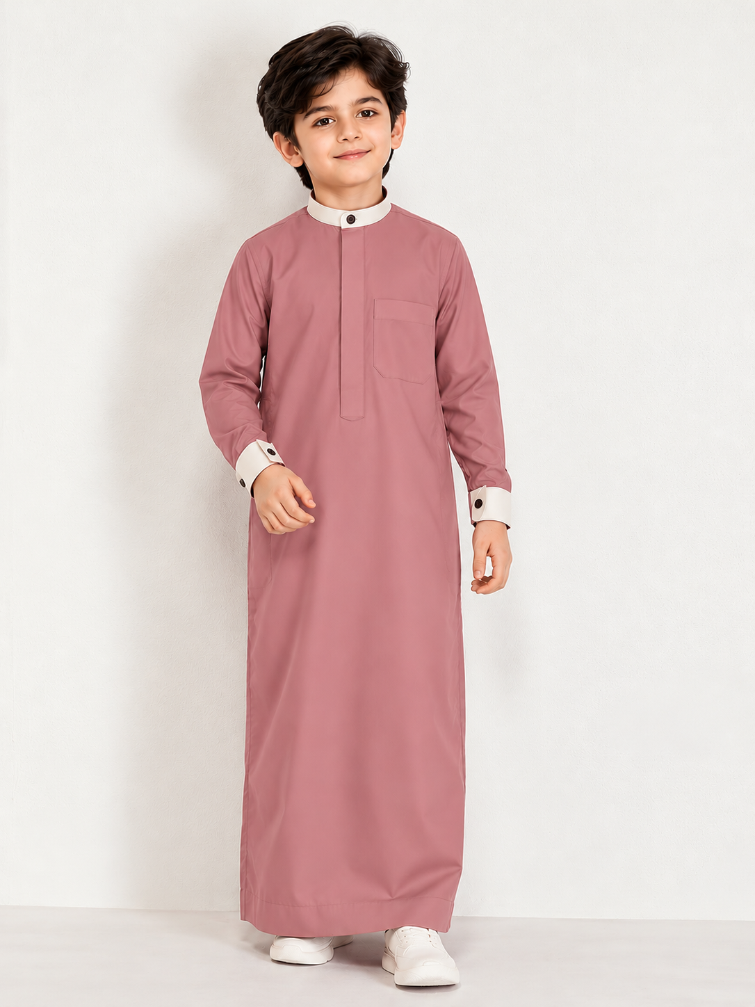 Give your little one a smart and elegant traditional look with the **Isliba Dusty Rose Thobe for Boys**. Featuring a sophisticated dusty rose color, a contrasting cream collar and cuffs, and a clean, minimal design, this thobe is perfect for everyday Islamic wear and special occasions. **Product Features:** - **Elegant Dusty Rose Color:** A modern and stylish shade for boys. - **Minimal Design:** Clean front placket with no embroidery for a simple, refined appearance. - **Contrast Detailing:** Cream stand collar and sleeve cuffs with dark buttons. - **Practical Chest Pocket:** Adds functionality while maintaining a neat look. - **Full Sleeves:** Designed for a classic traditional appearance. - **Versatile Occasion Wear:** Suitable for Eid, Ramadan, Jummah prayers, family gatherings, and festive occasions. **Product Details:** - Brand: Isliba - Product Type: Boys' Thobe / Arabic Jubba - Color: Dusty Rose - Collar: Cream Stand Collar - Sleeves: Full Sleeve - Design: Plain / Minimal - Available Sizes: As per size selection Choose Isliba for a timeless Islamic outfit that combines simplicity, style, and traditional elegance.